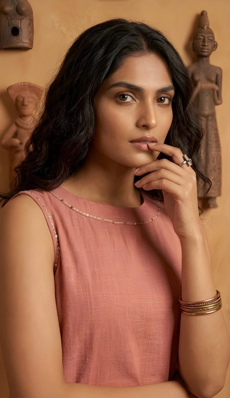 Woman in a pink top with decorative elements in the background