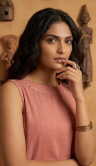 Woman in a pink top with decorative elements in the background