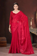 Woman wearing a red saree with a dark background