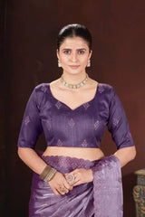 Woman wearing a purple saree with a dark background