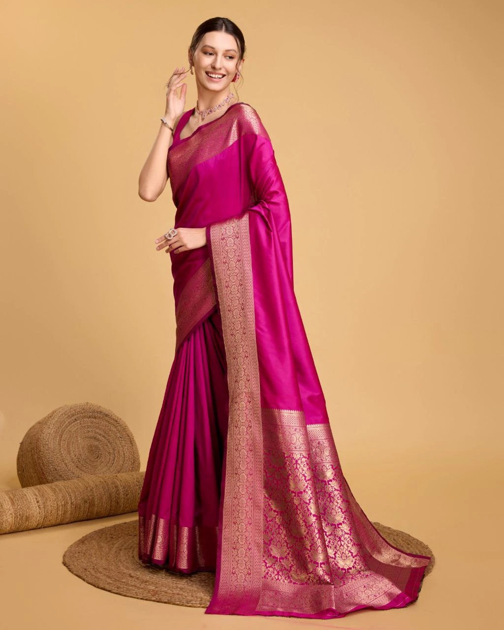Woman wearing a pink saree with a beige background