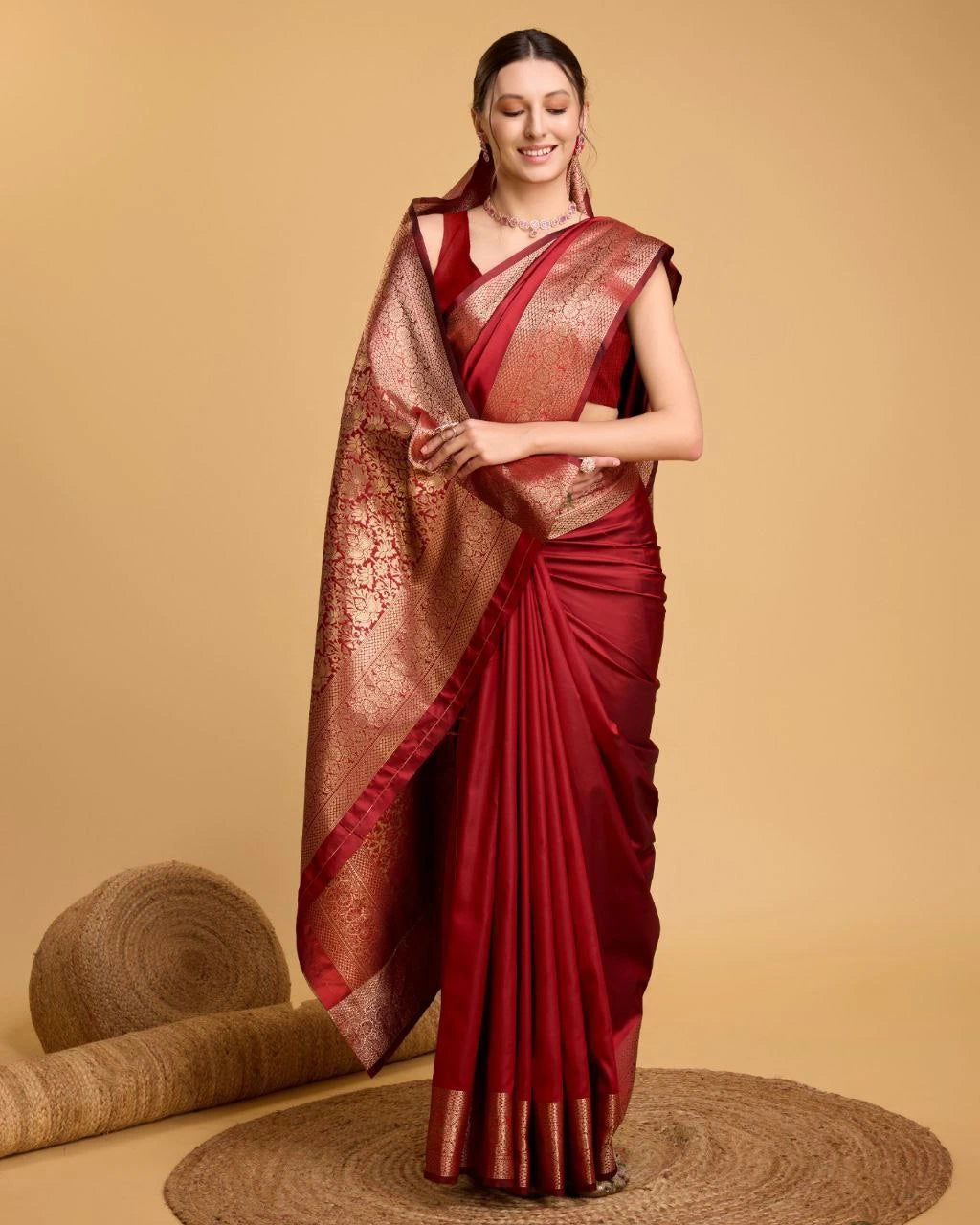 Woman wearing a red saree with gold border on a beige background