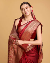 Woman wearing a red saree with gold border on a beige background