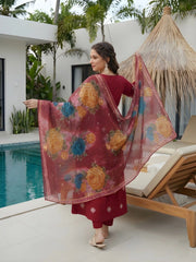 Woman in a red traditional outfit with a floral dupatta by a poolside.