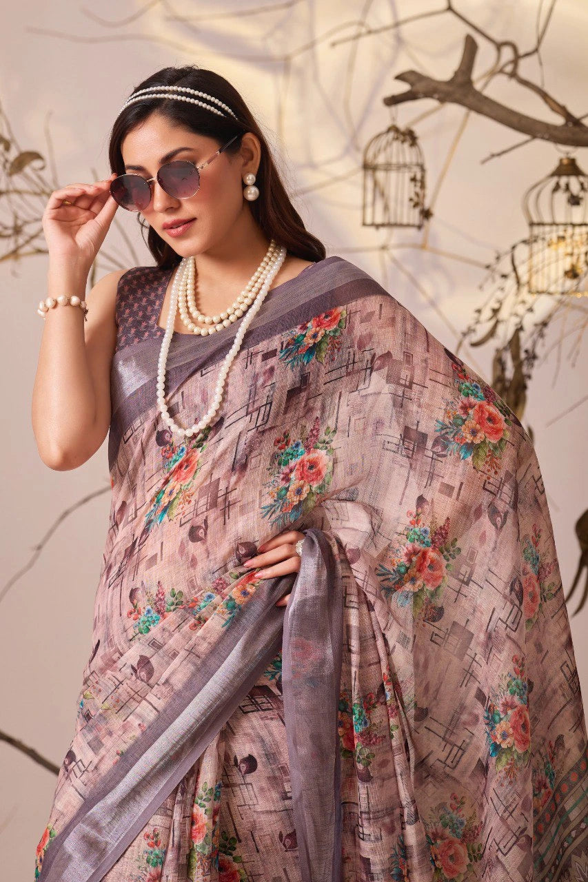 Woman wearing a floral saree with a gray border, holding sunglasses, against a decorative background.