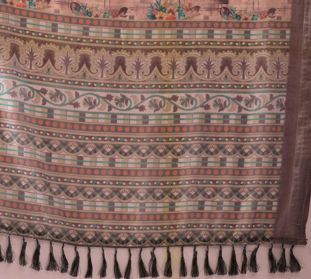 Patterned fabric with tassels on a plain background
