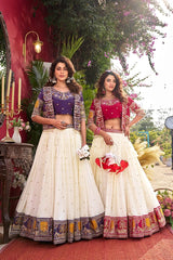 Two women in traditional Indian attire standing outdoors with decorative elements.