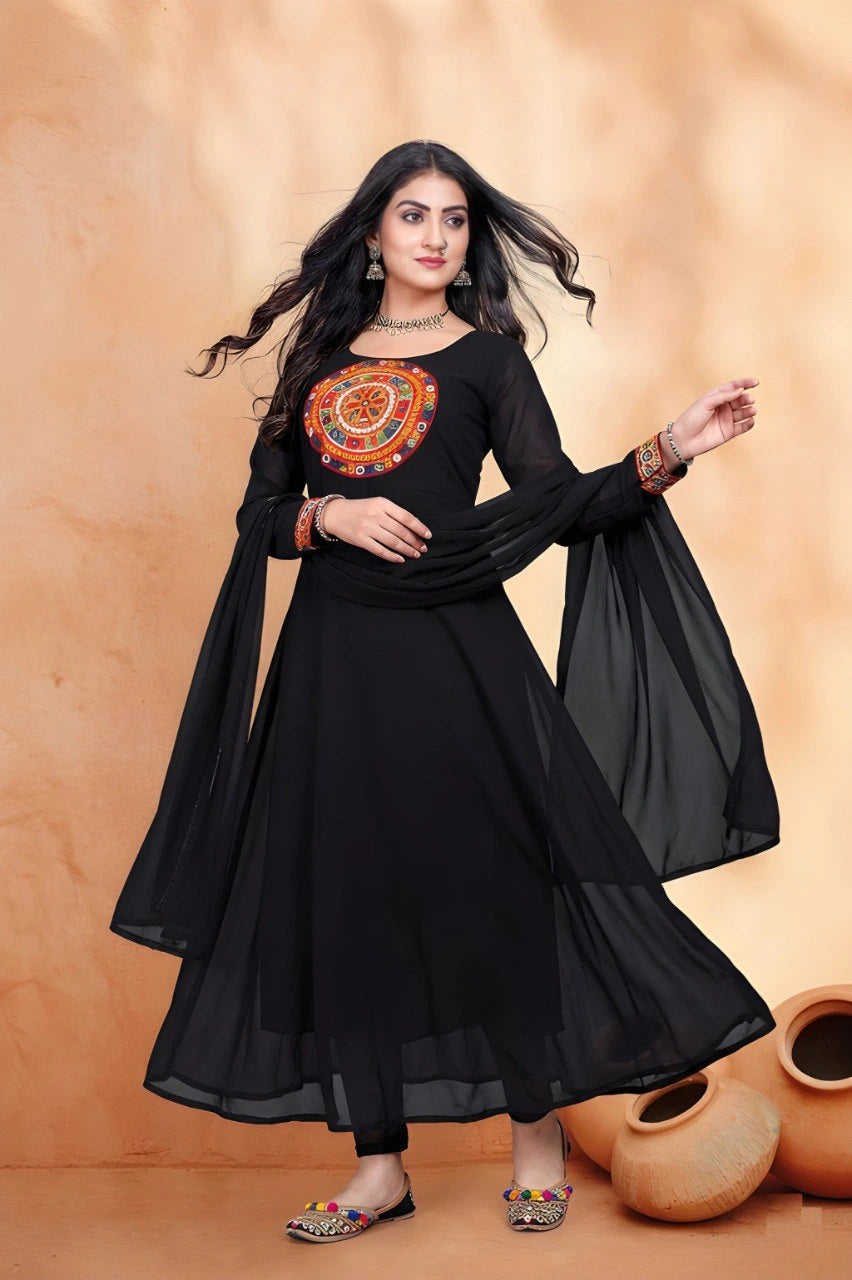 Woman wearing a black traditional outfit with colorful embroidery against an orange background