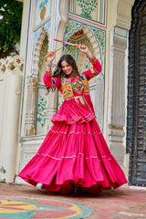 Woman in a colorful traditional outfit dancing in front of an ornate architectural background