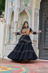 Woman in traditional outfit standing in front of a decorative architectural background