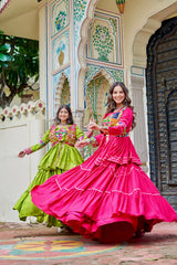 Two women in colorful traditional dresses posing in front of a decorative building.