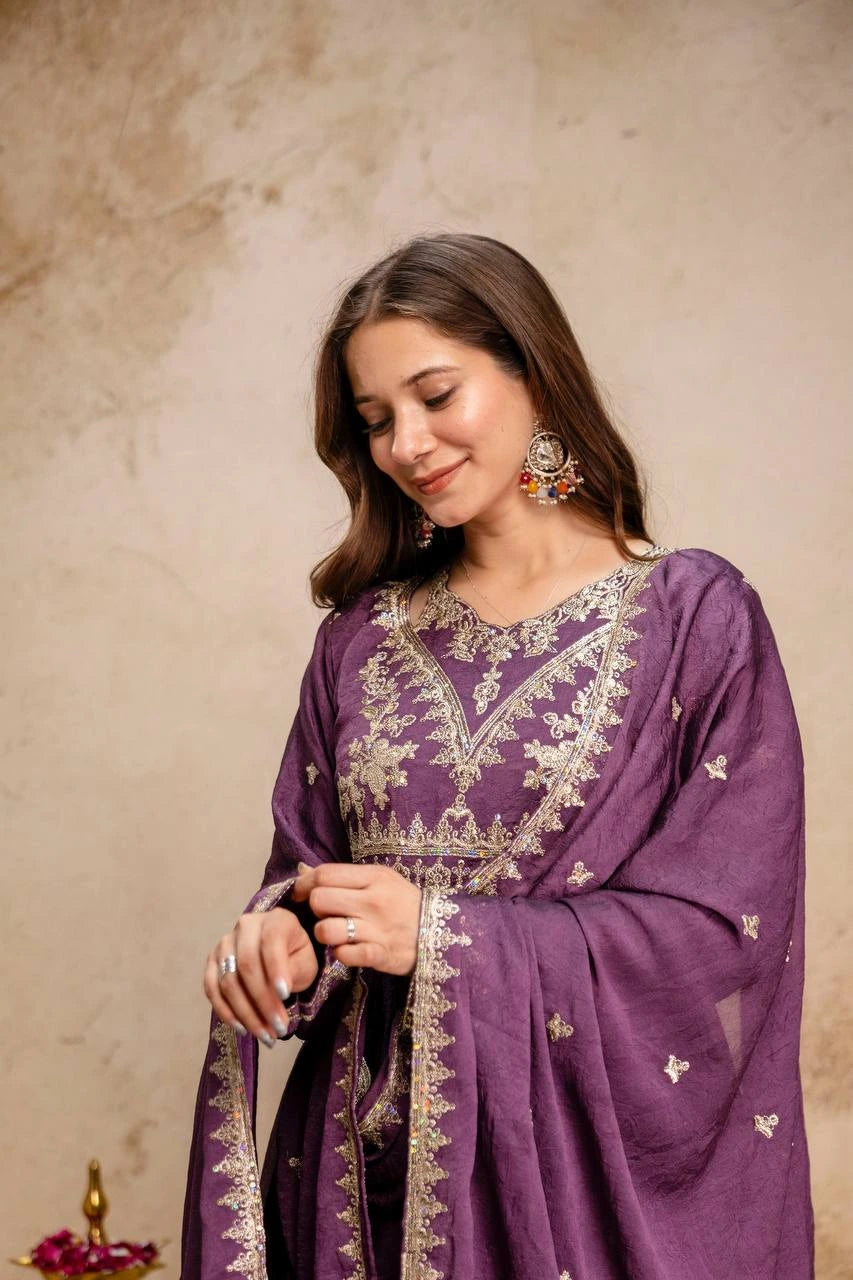 Woman wearing a purple embroidered dress against a beige background