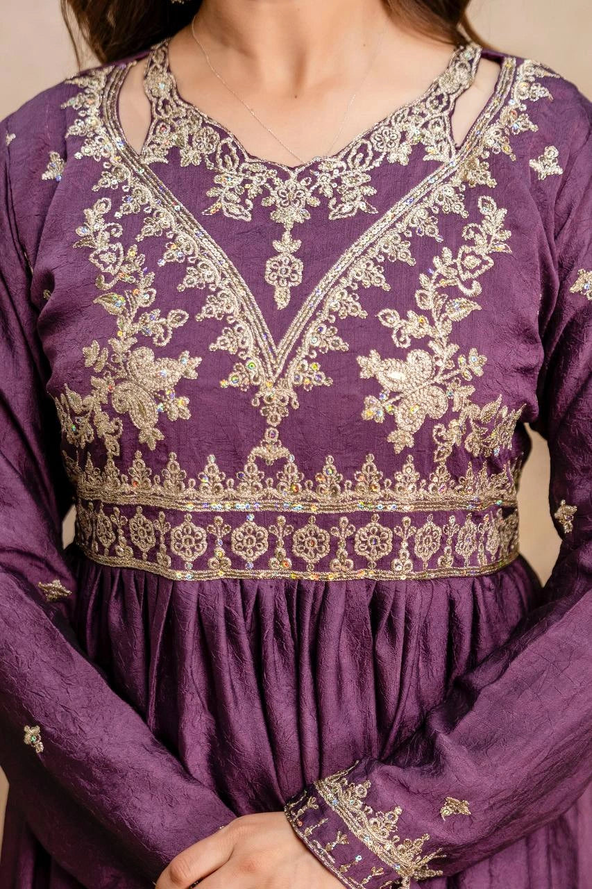 Purple dress with intricate gold embroidery on a neutral background