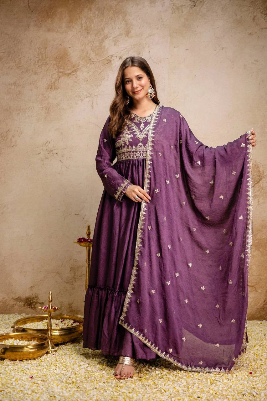 Woman in a purple traditional outfit with embroidery against a beige background