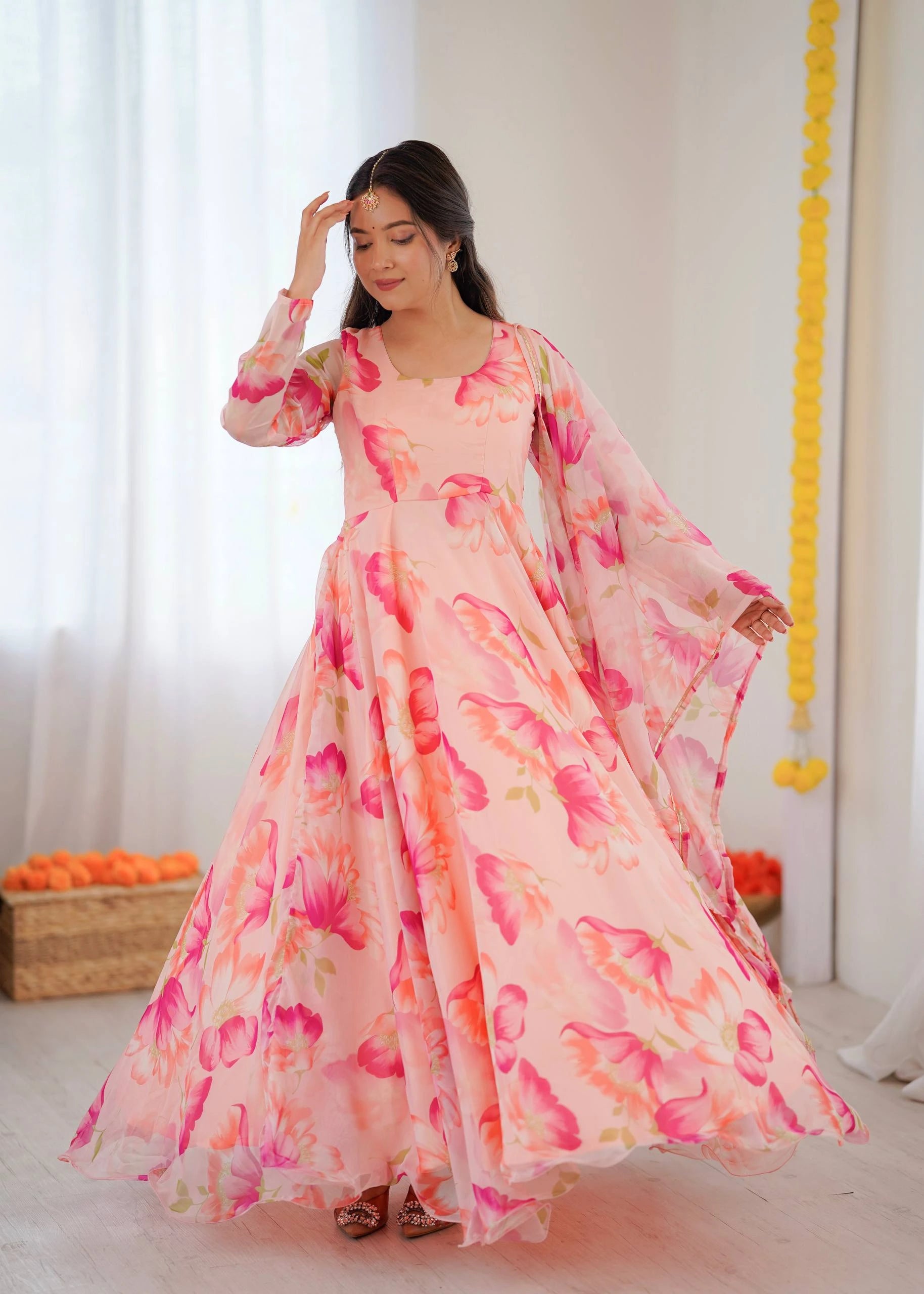 Woman wearing a pink floral dress with a white background