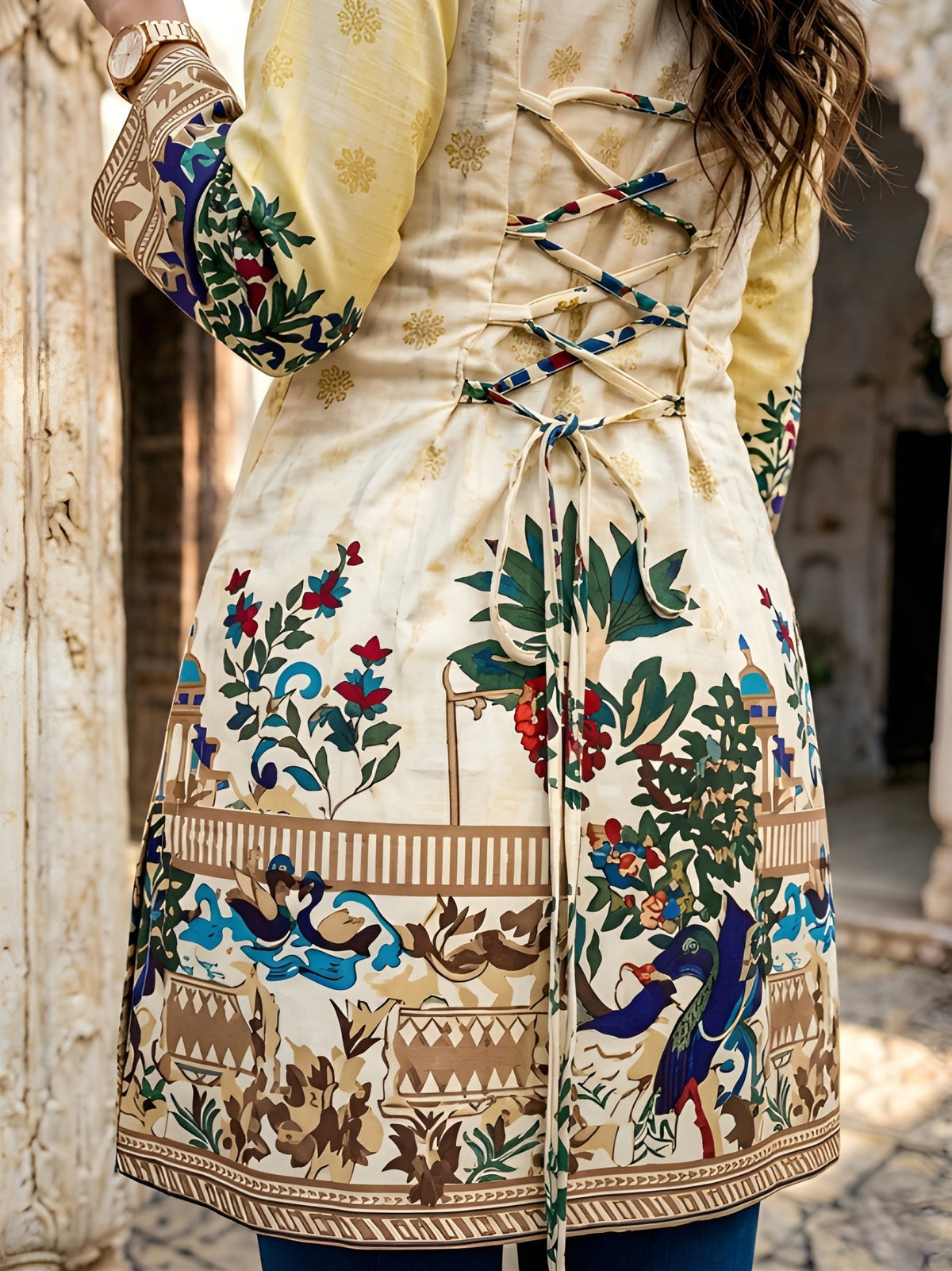 Close-up detail of dori tie-up back on yellow Kalamkari short kurti showing floral and elephant print on cotton fabric