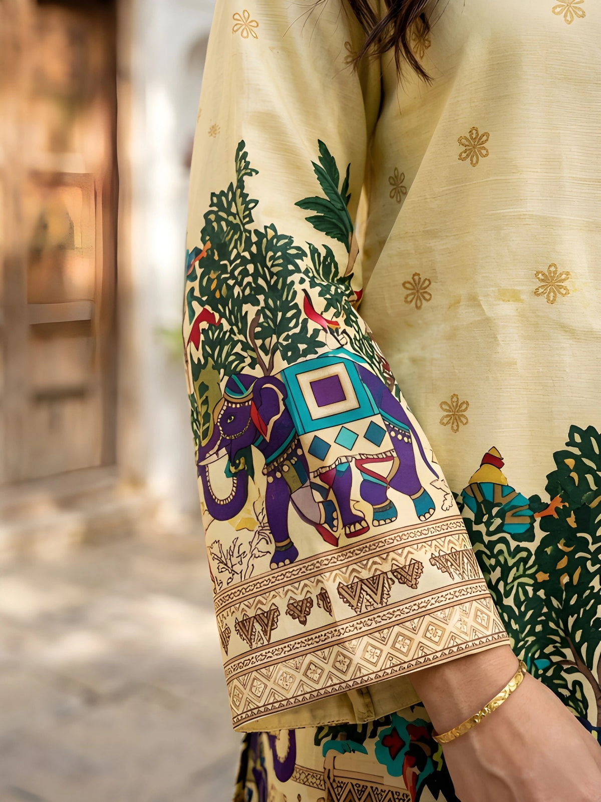Sleeve detail of yellow Kalamkari cotton short kurti featuring decorated elephant and tropical tree motifs in vibrant colors