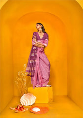 Woman in pink silk saree with purple lotus border against yellow set