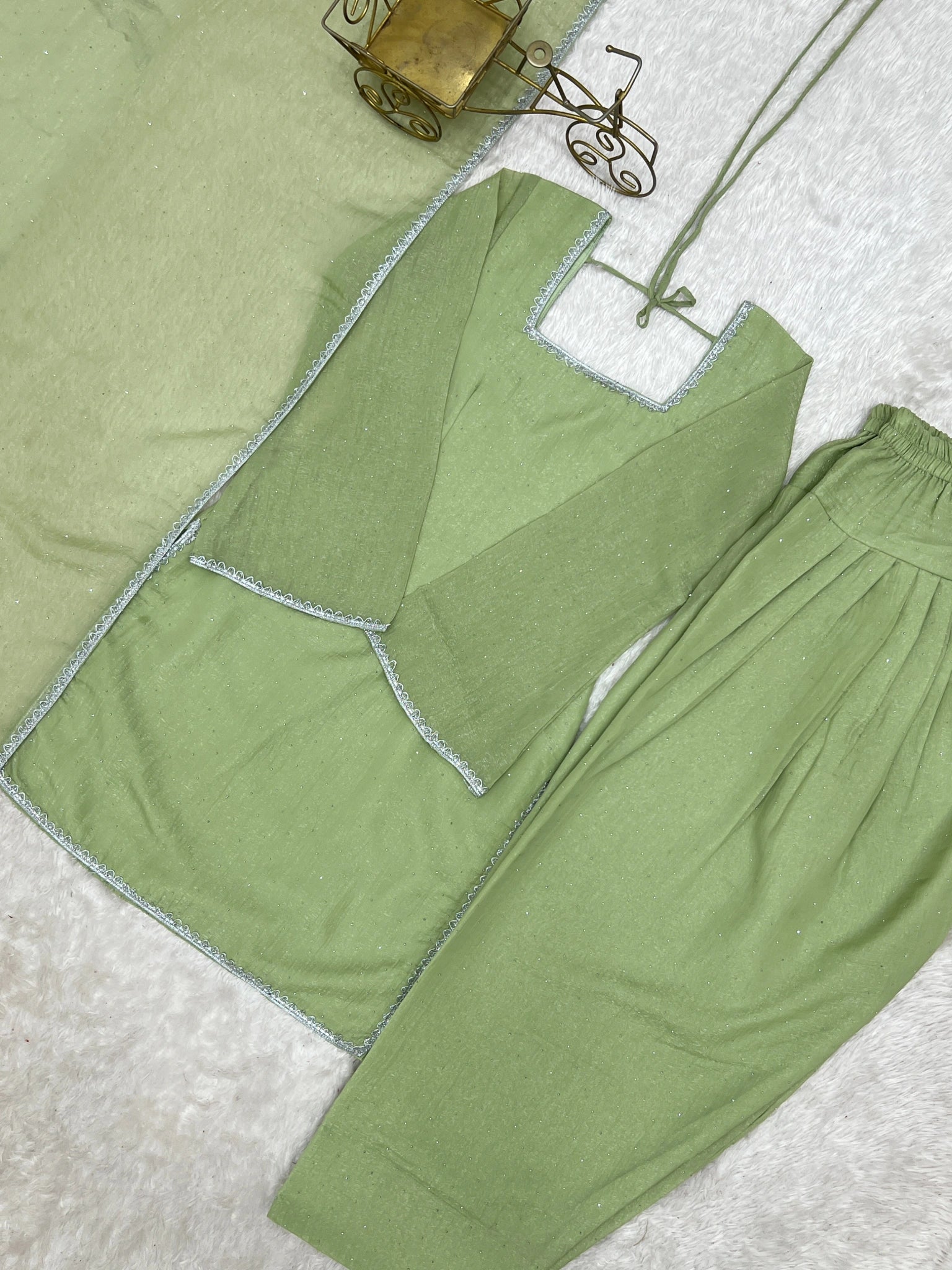 Pista green suit flat lay - lace border detail