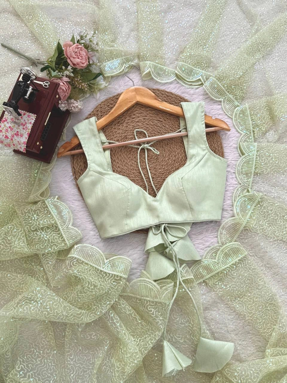 Pista saree blouse piece flat lay with scalloped border