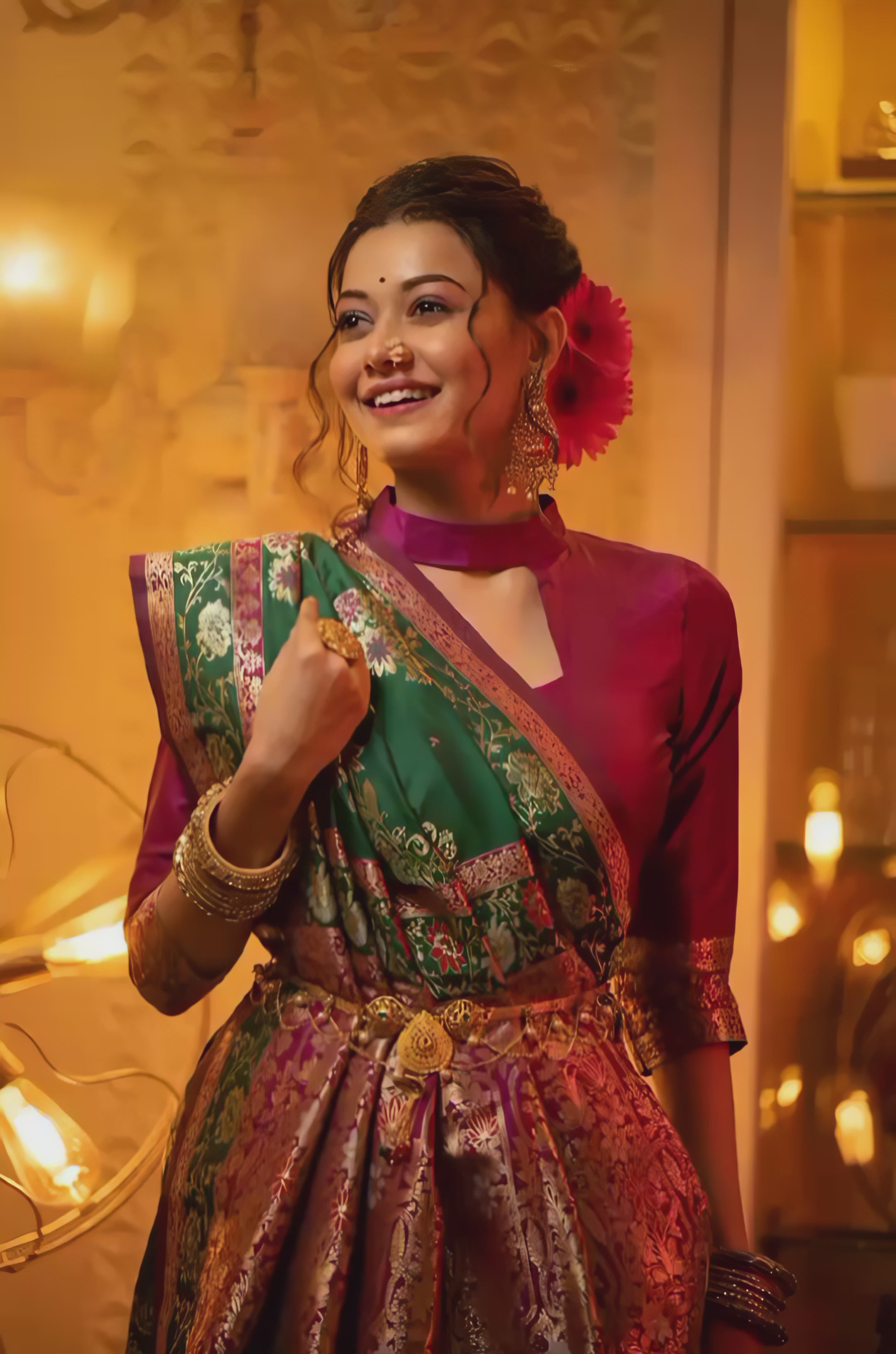 A woman models a luxurious Black Soft Banarasi Silk Saree. The saree features dense, multi-colored Zari weaving of gold and pink florals, and a wide pallu with heavy gold and Fuchsia Pink accents. She wears a high-neck magenta blouse and gold jewelry, posing in a dramatically lit antique setting.