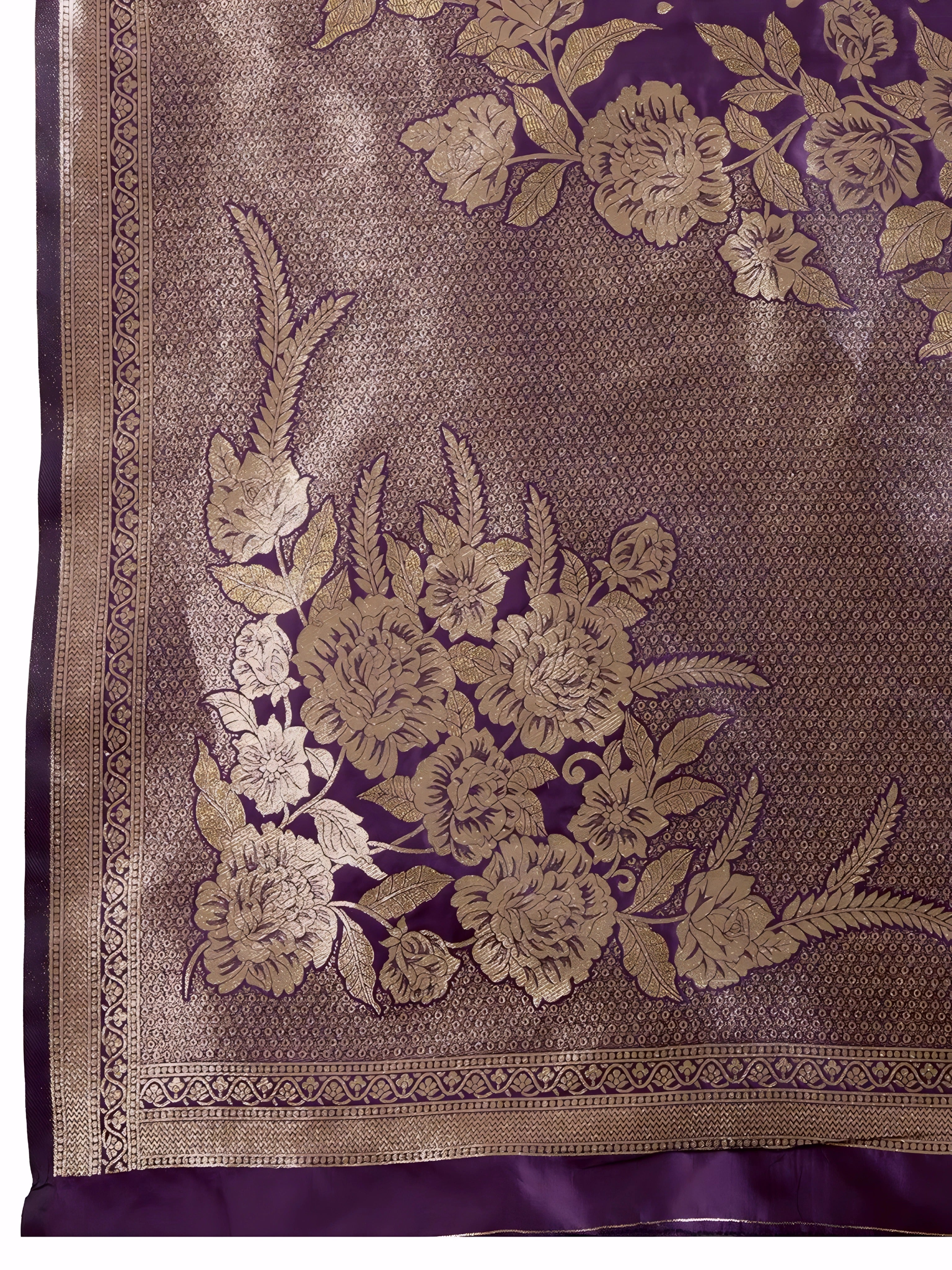 A woman models a luxurious Deep Purple Soft Kanjivaram Silk Saree. The saree features striking large floral and scattered motifs woven in metallic gold Zari on the body and wide pallu. She wears a matching purple sleeveless blouse and accessorizes with a heavy gold Kundan choker necklace and earrings.