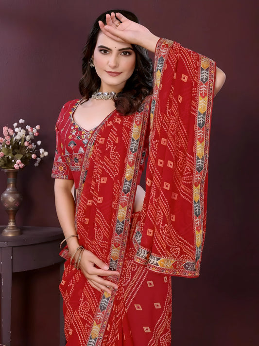 Woman wearing a red digital print saree with embroidery work and a contrast patterned border, paired with a matching blouse in an indoor studio product image, Indian ethnic wear