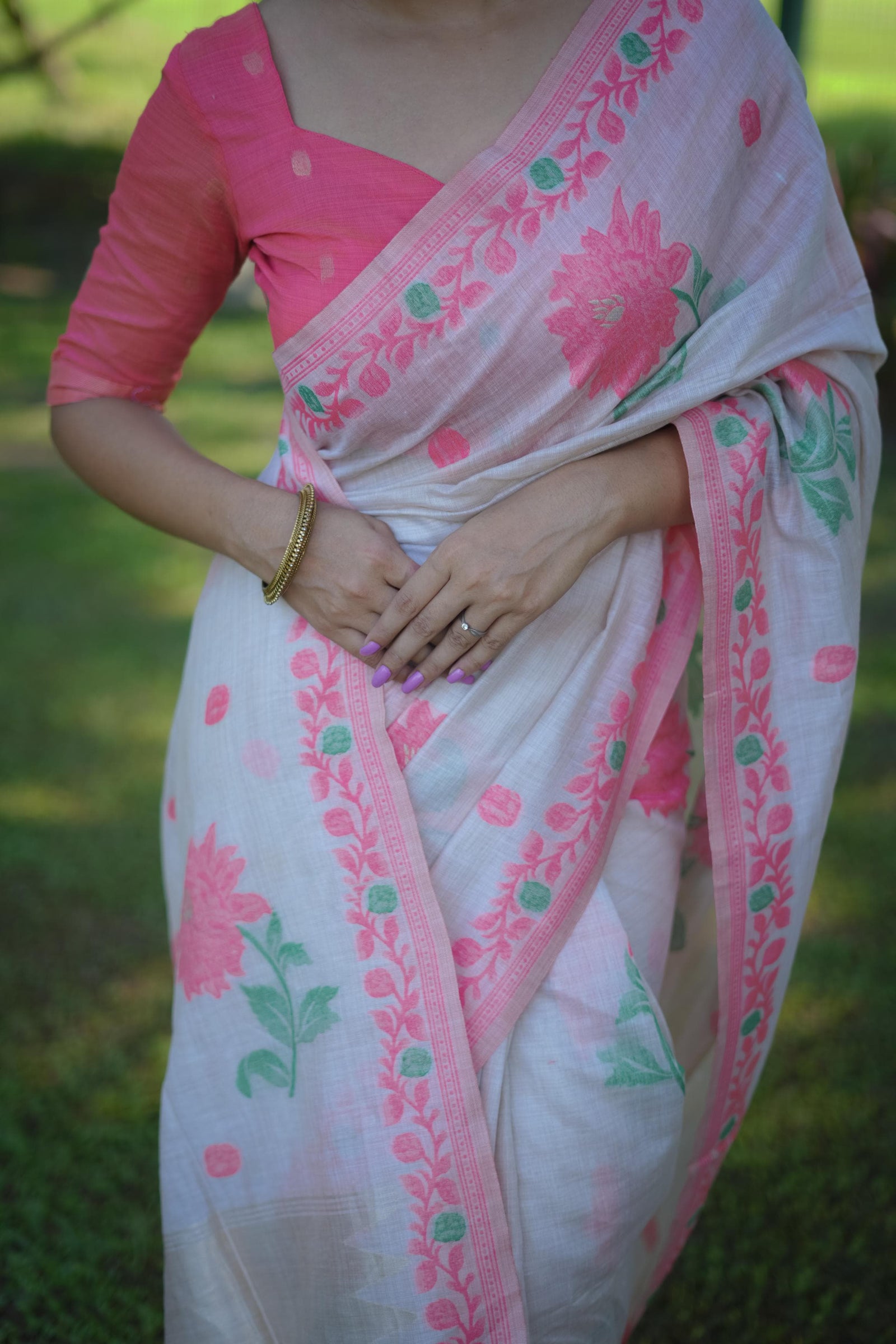 Woman wearing a pink Resham weaving saree outdoors