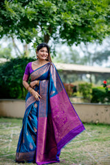 Smiling woman in teal blue zari work saree showcasing traditional Indian fashion in an outdoor setting