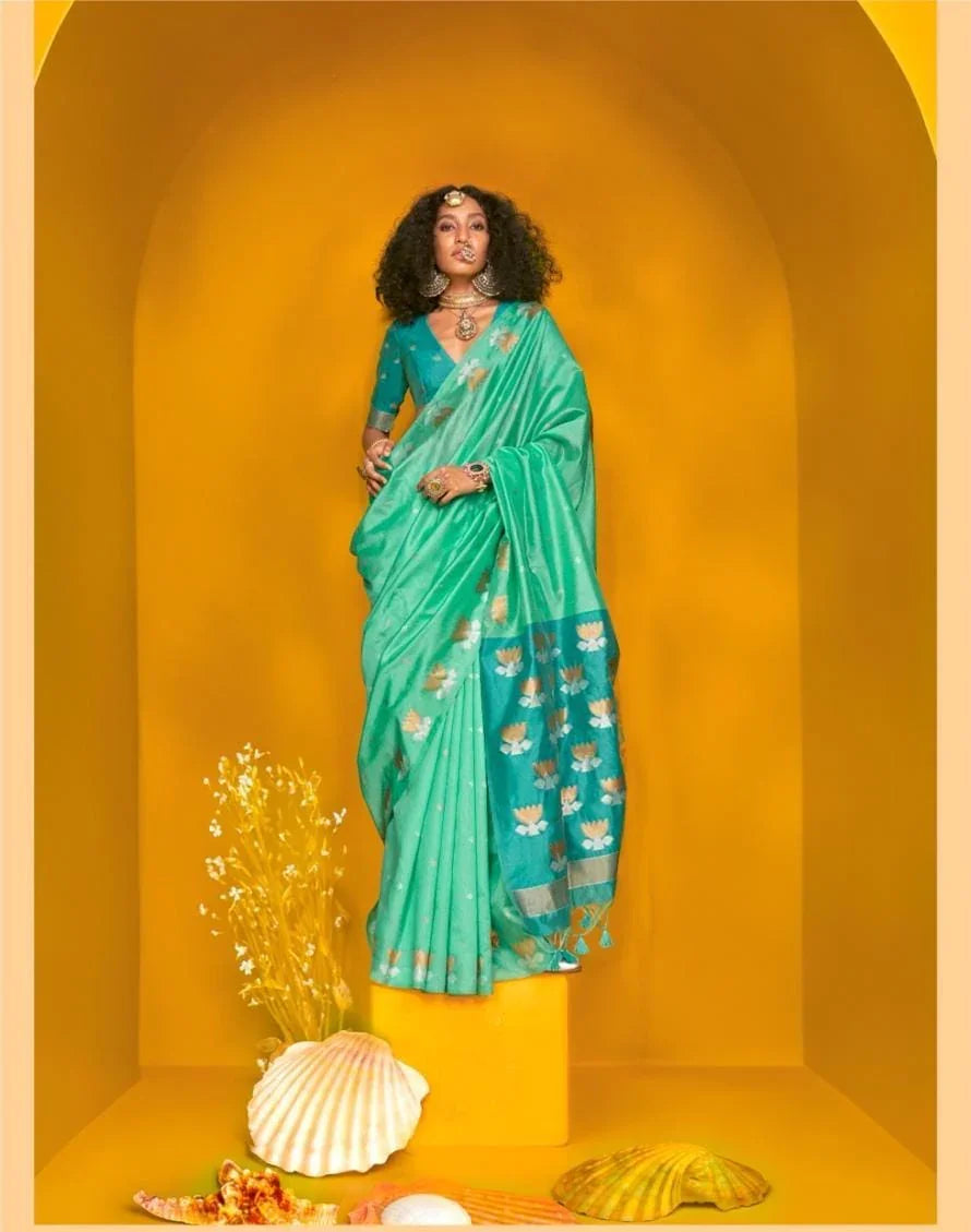 Woman in a teal saree with beautiful zari work design