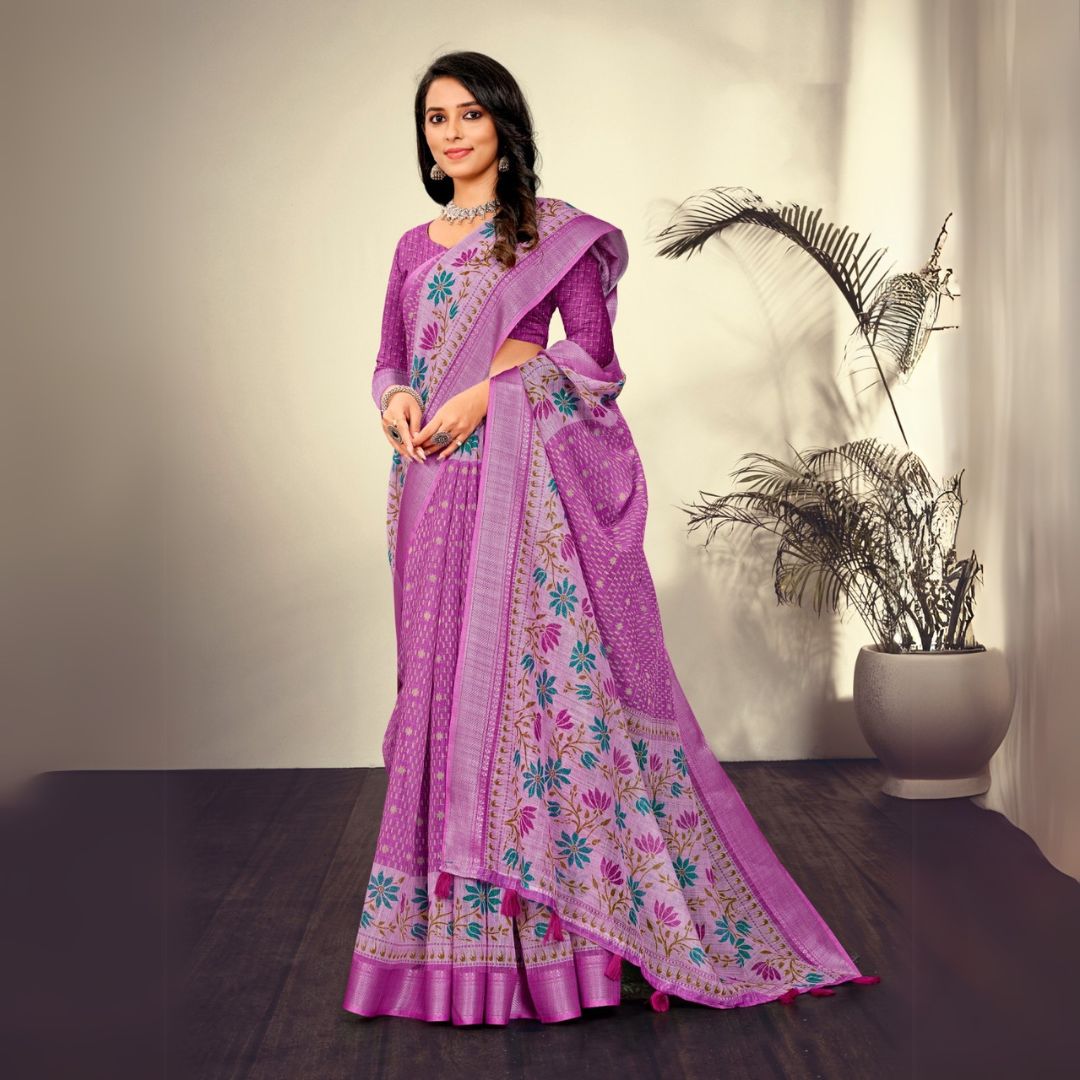 Woman in a traditional quartz pink saree with printed patterns standing indoors near a potted plant