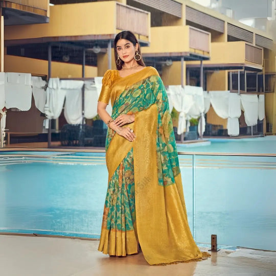 Woman in a tropical green zari work saree with floral patterns and golden pallu, styled elegantly with statement jewelry by the poolside