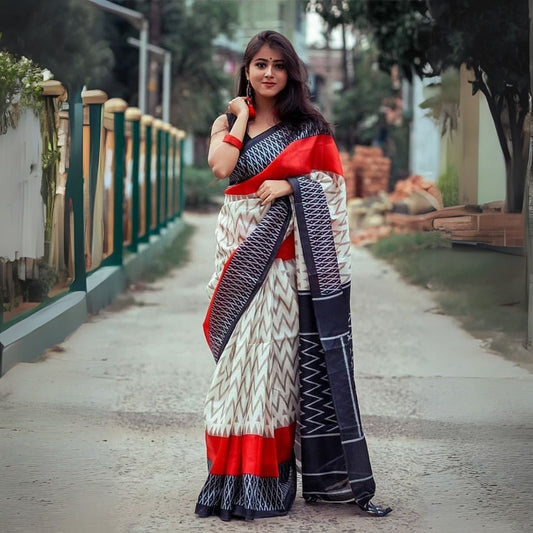 Woman in a white Jaipur block print saree with red and black border, traditional ethnic wear styled with bangles and earrings on a street background