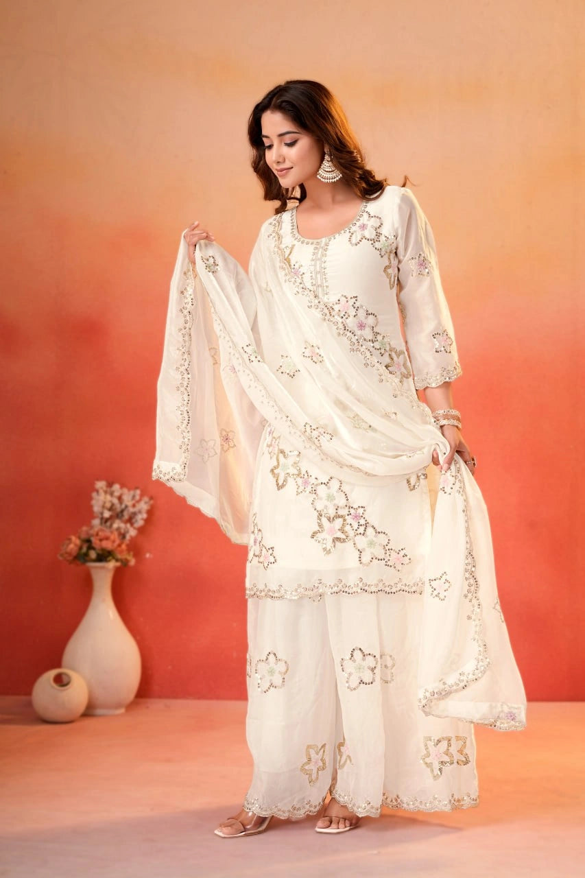White Sharara Suit model holding sheer dupatta spread showing sequins booti border