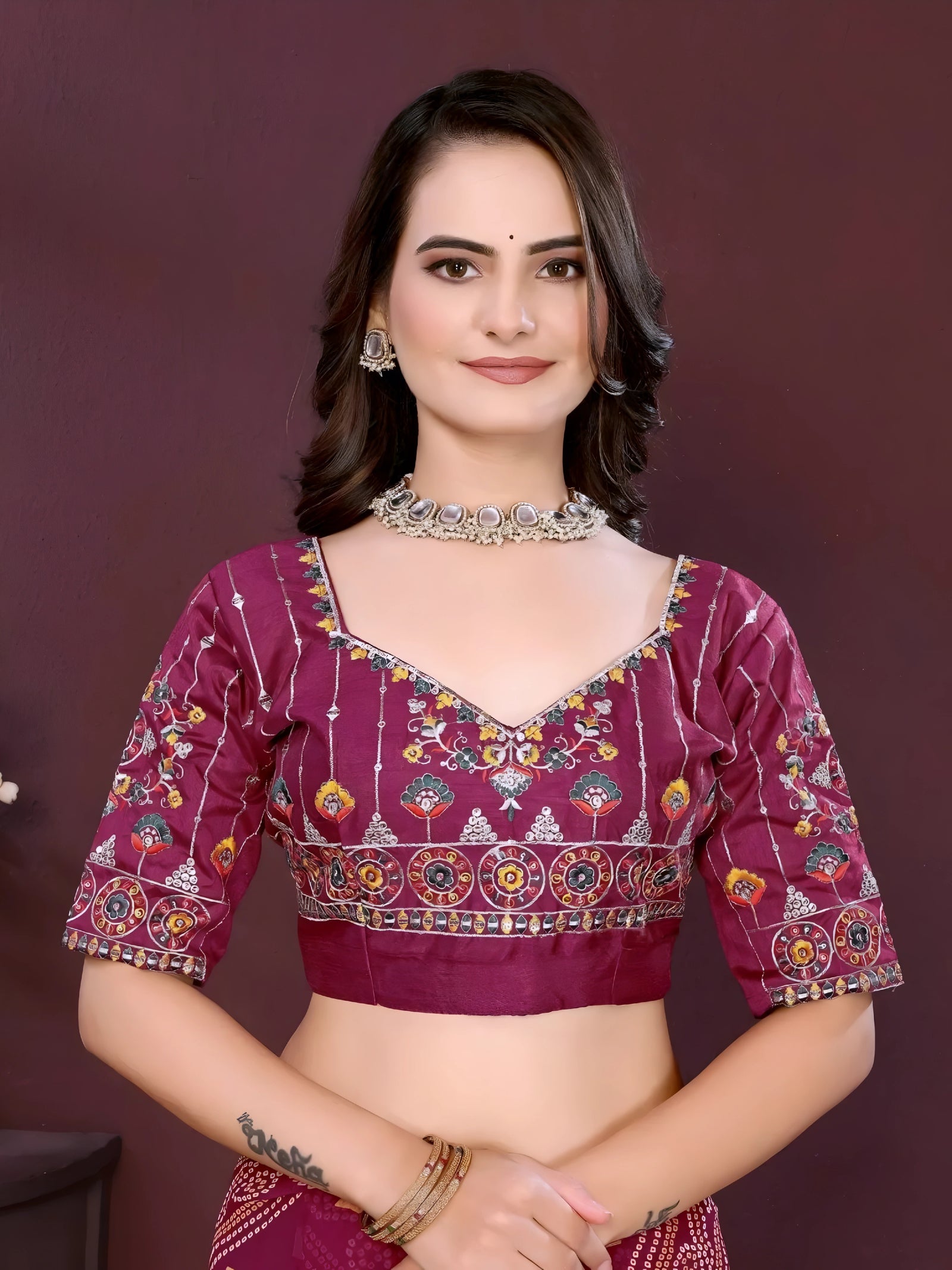 Woman wearing a wine color digital print saree with embroidery work and a contrast patterned border, paired with a matching blouse in an indoor studio product image, Indian ethnic wear