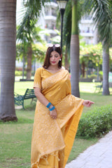  Woman wearing yellow traditional weaving saree posing gracefully in a lush garden setting